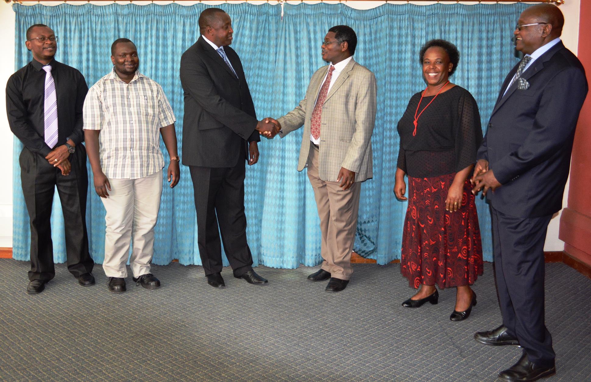 NCCK General Secretary Rev. Canon Peter Karanja greets the board Chairman for Jumuia Resorts Limited Board Mr. Sam Kotut. Looking on are other board members.